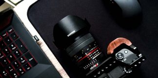 A photo of a camera sitting next to a laptop