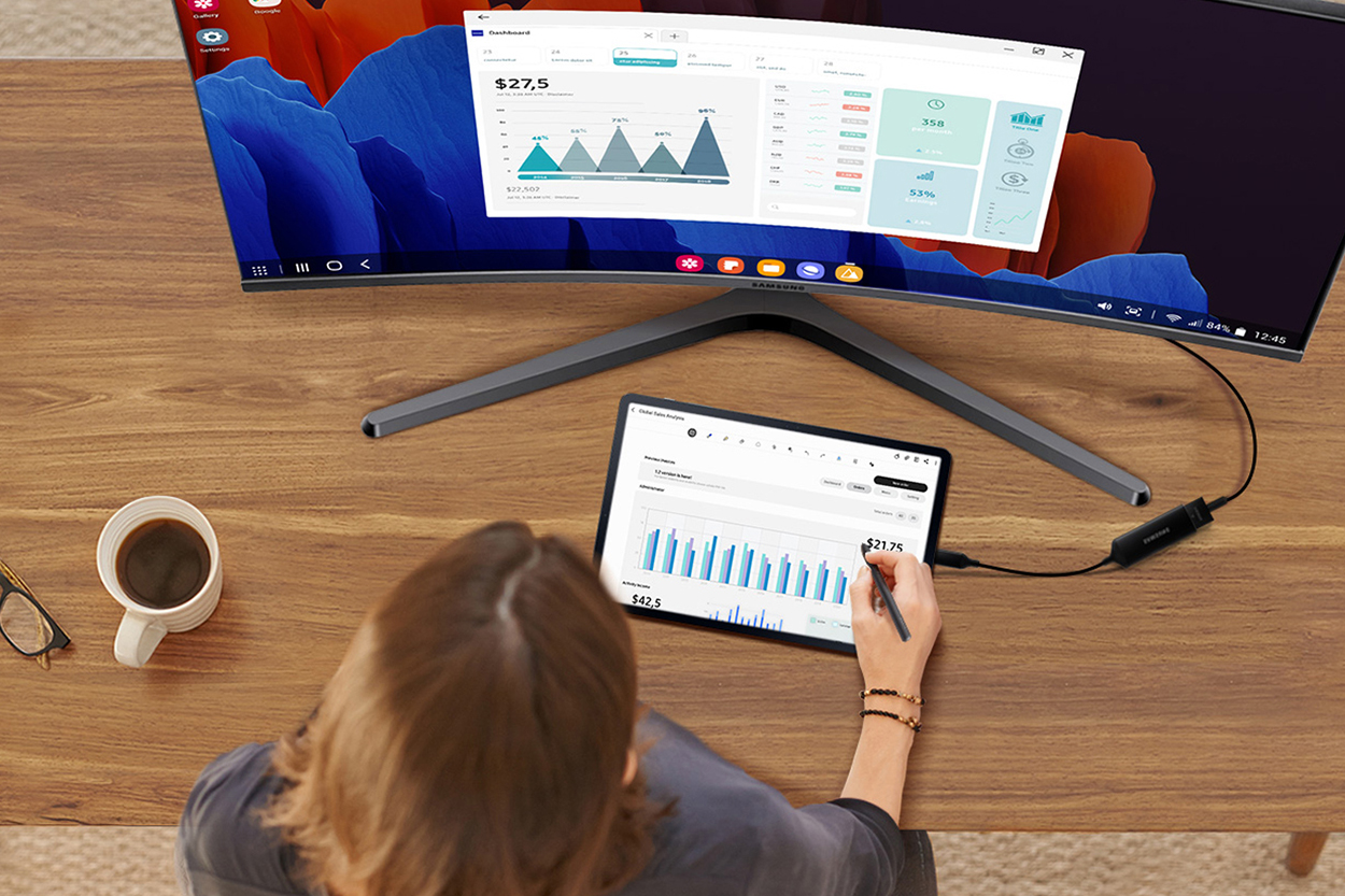 Woman working on a tablet with a monitor